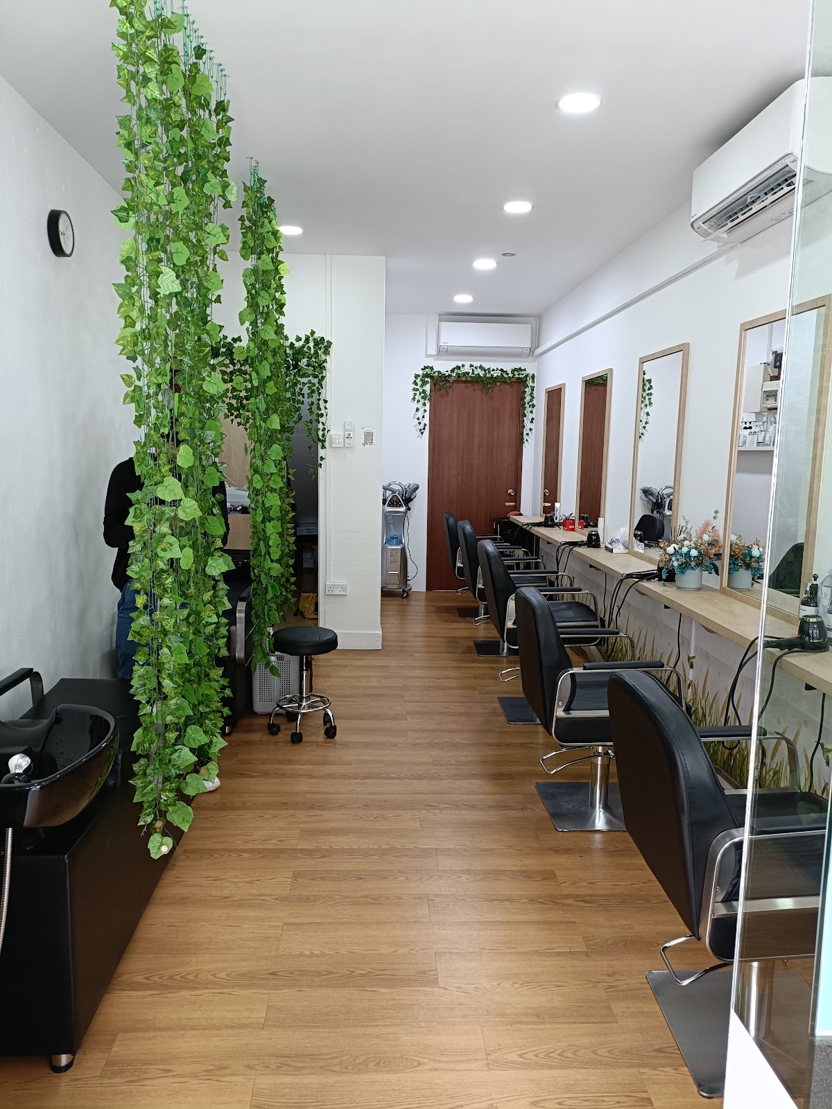 Another view down the salon aisle, warm wood tones and greenery